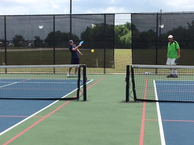 Pickleball Player hitting the ball in between the nets