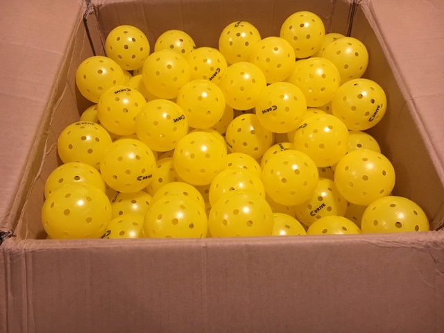 A shipping box full of about 250 USAPA approved C DRIVE Pickleballs